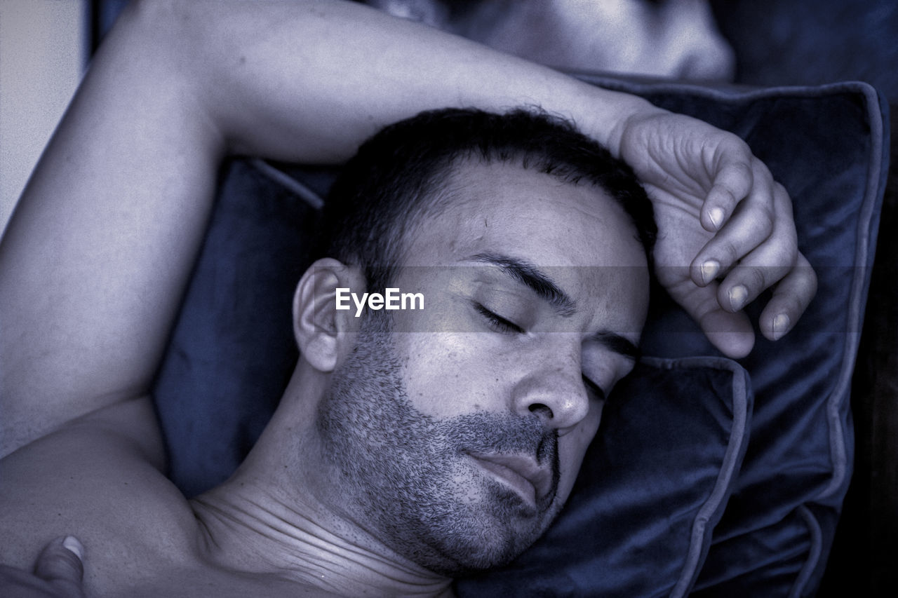 Close-up of man sleeping on bed