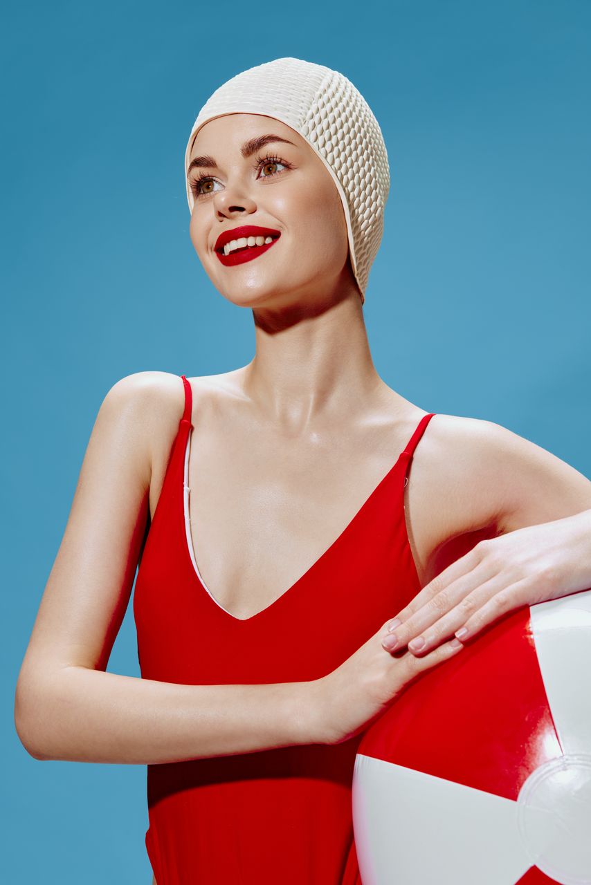 portrait of young woman with arms raised against blue sky