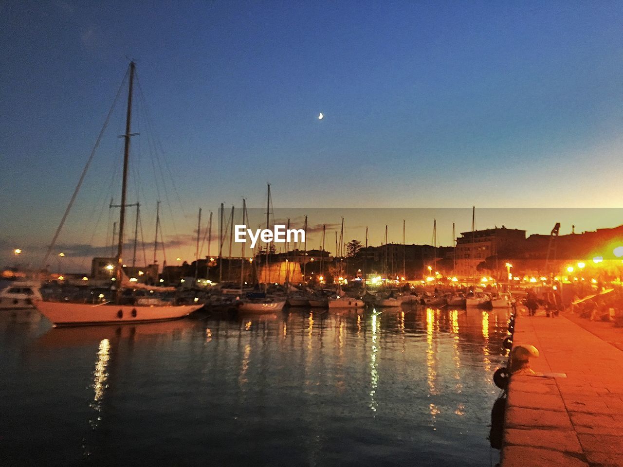 SAILBOATS MOORED AT HARBOR