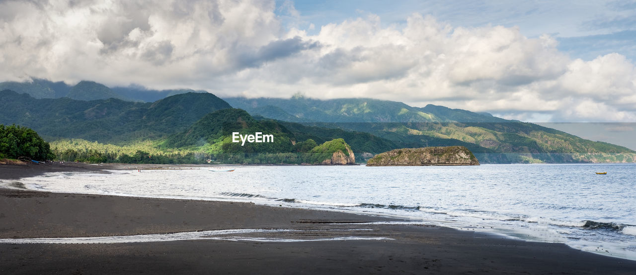 Scenic view of sea and mountains against sky