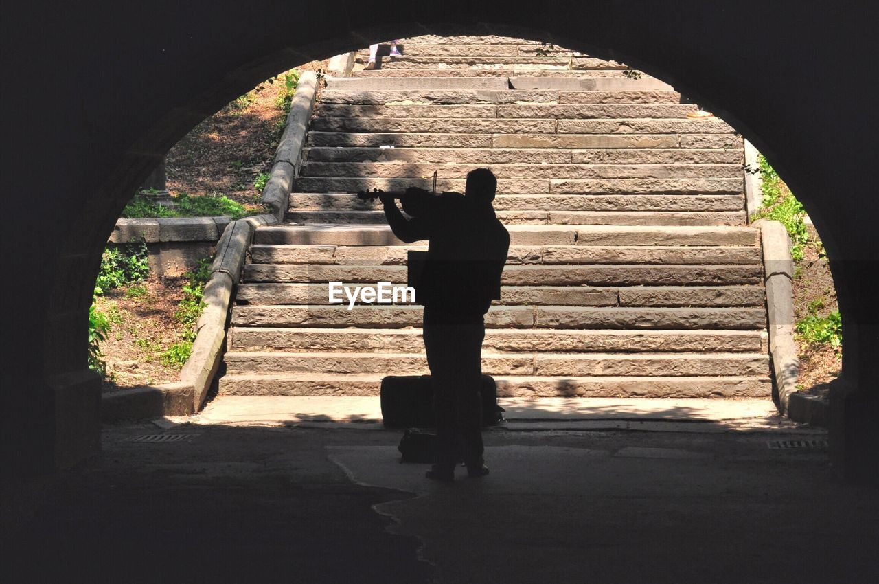 SILHOUETTE MAN STANDING ON STAIRCASE