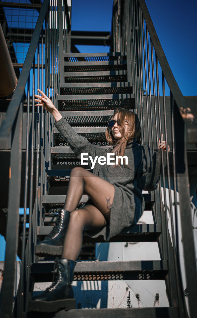 Low angle view of woman sitting on staircase