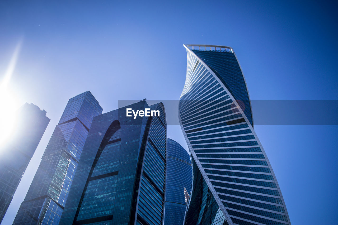 Low angle view of modern buildings against clear blue sky