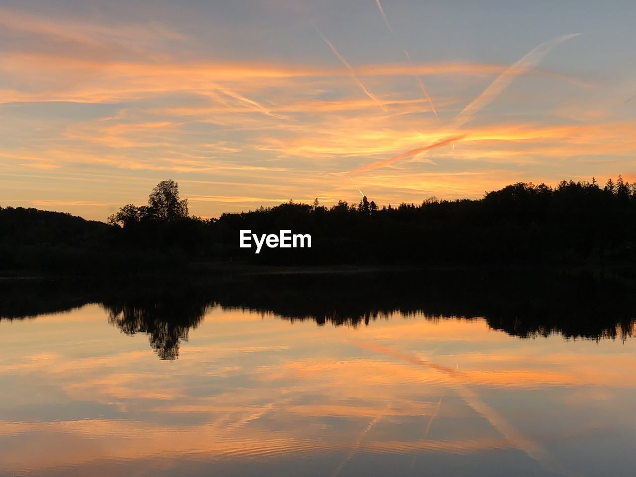 Scenic view of lake against orange sky