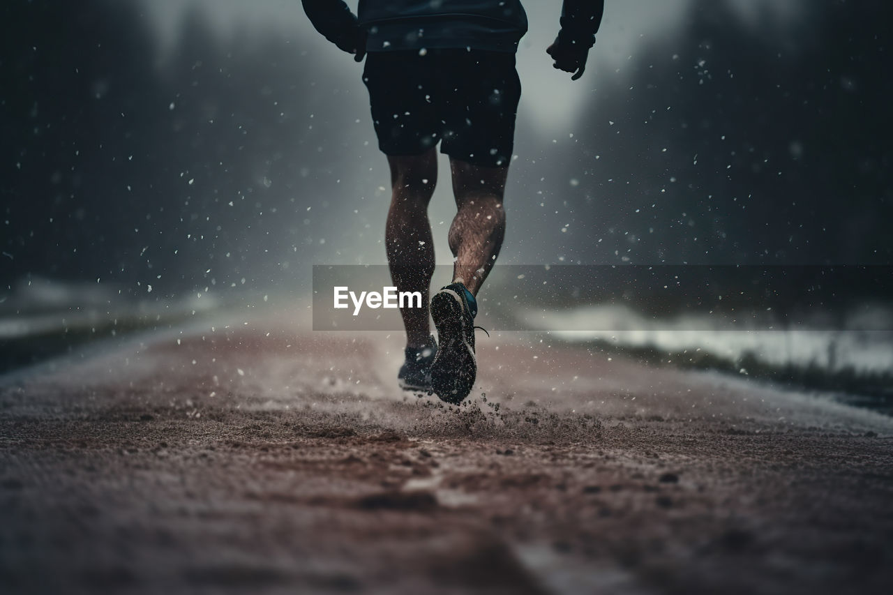 low section of man walking on snow