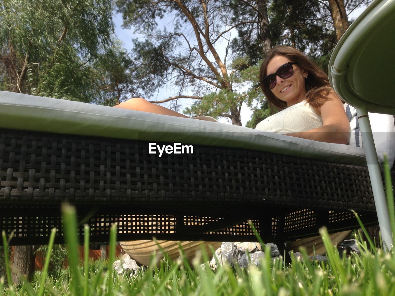 Low angle view of young woman sitting on lounge chair