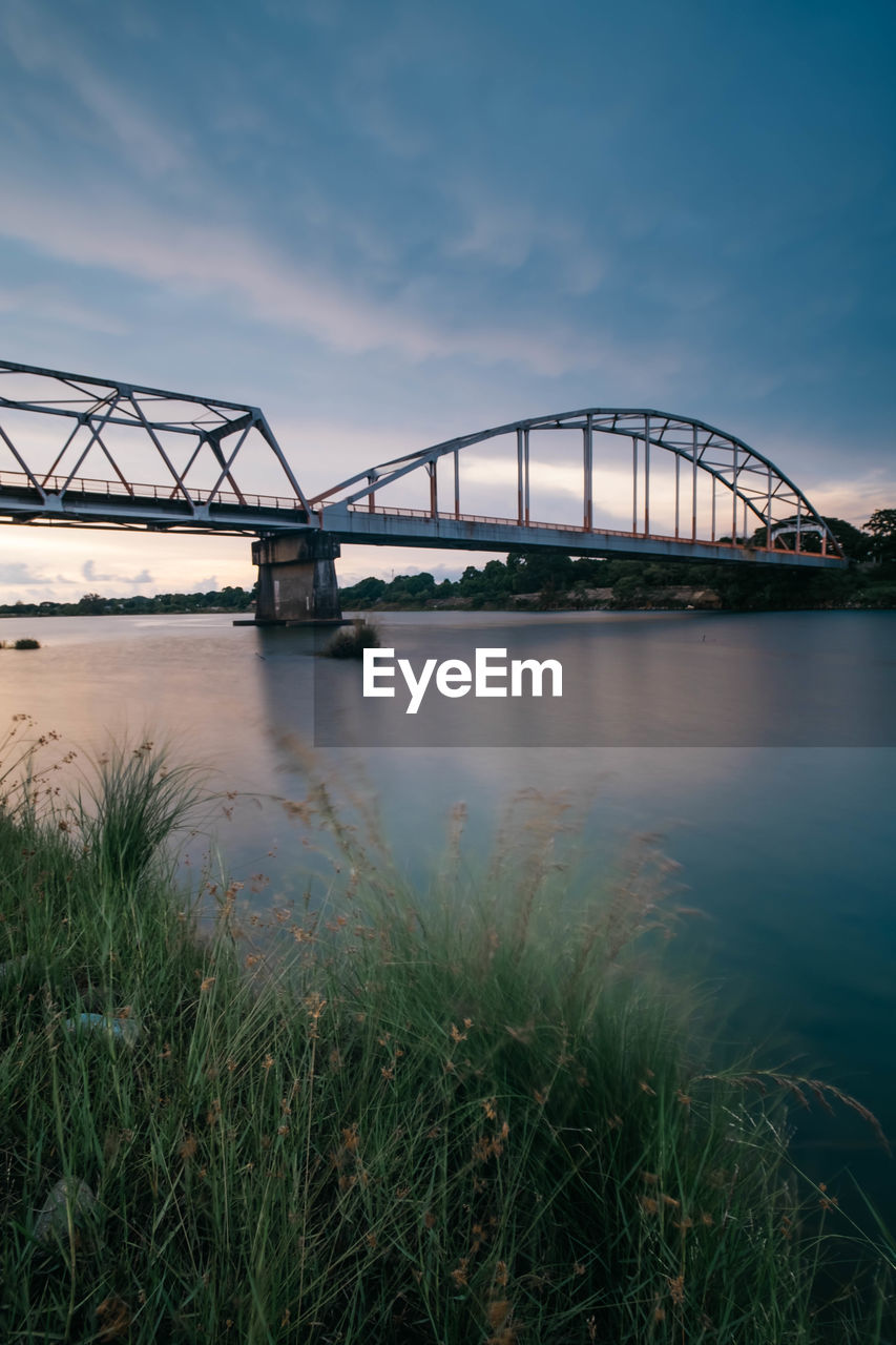 View of bridge over river against cloudy sky