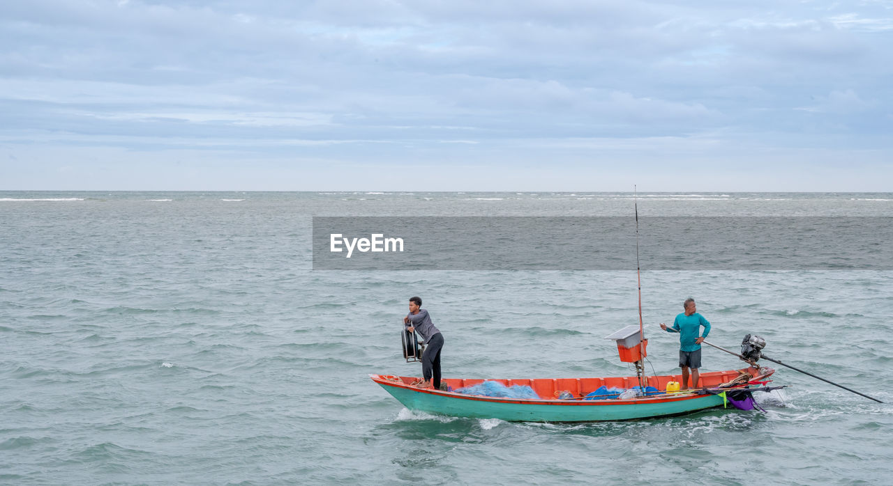 PEOPLE IN SEA AGAINST SKY