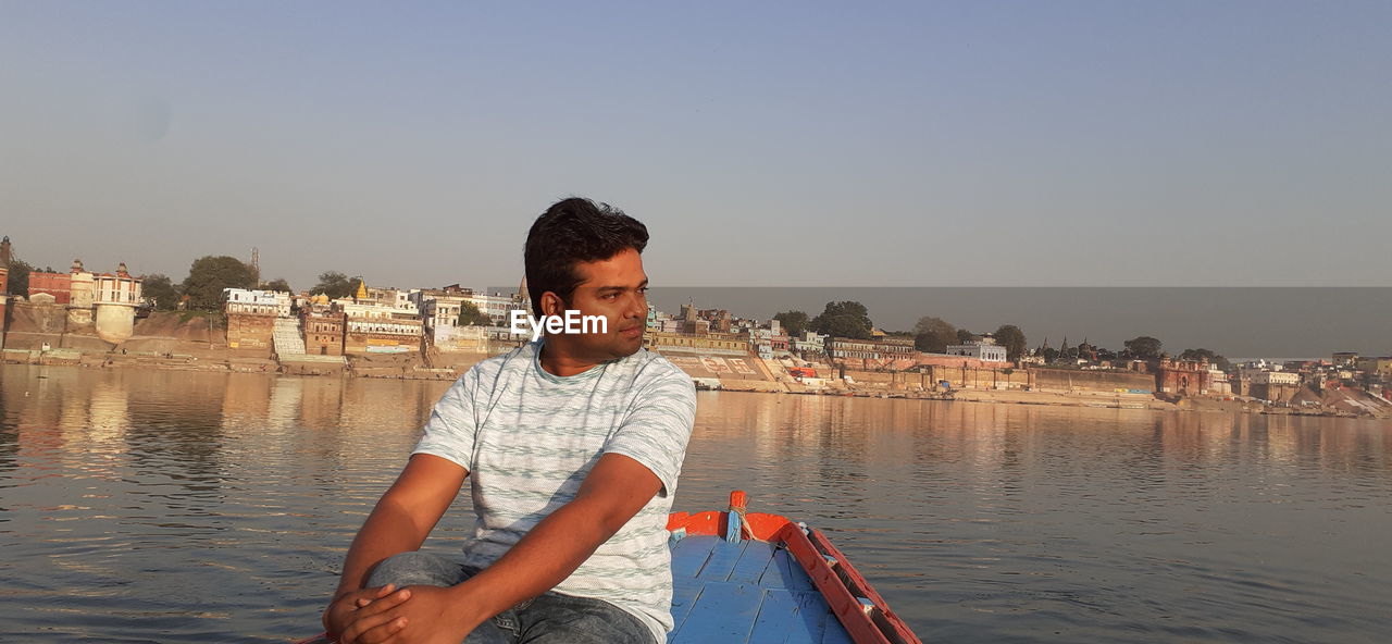 MAN ON BOAT AGAINST SKY