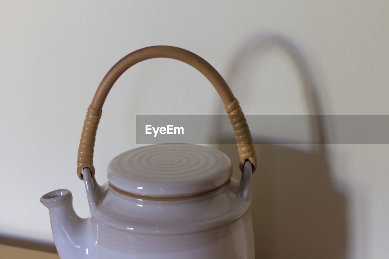 Close-up of teapot against wall