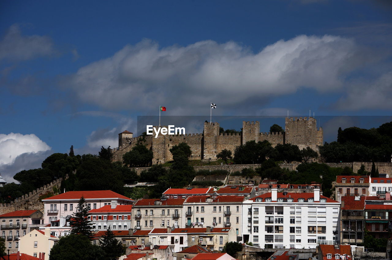 Castle on hill against cloudy sky