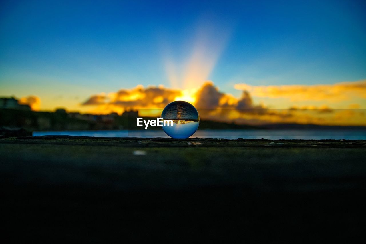 CLOSE-UP OF A CRYSTAL BALL ON THE BEACH