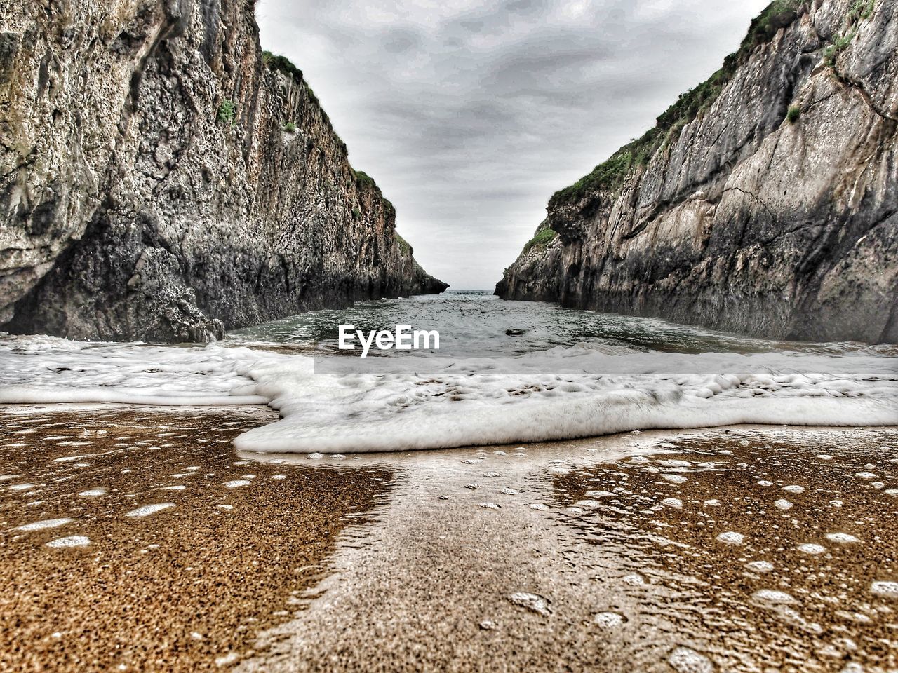 Surface level of rocks on beach against sky