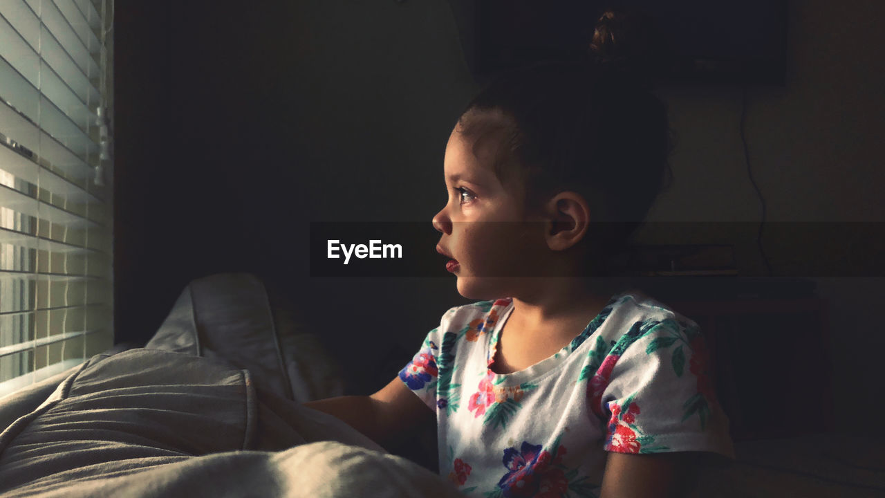 Girl looking away while sitting at home