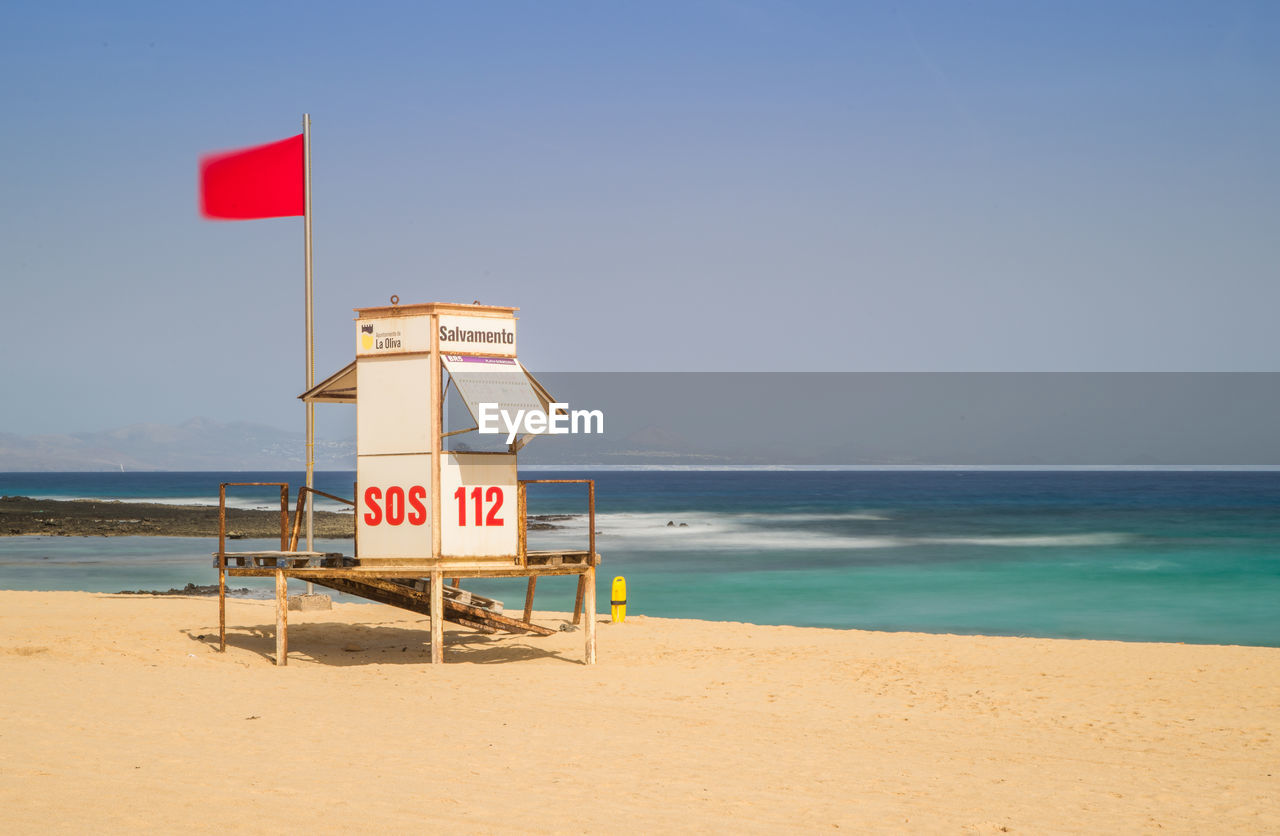 First aid sign on beach against clear sky