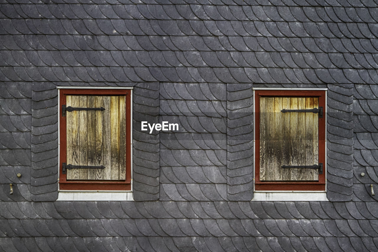 LOW ANGLE VIEW OF WINDOW ON HOUSE WALL