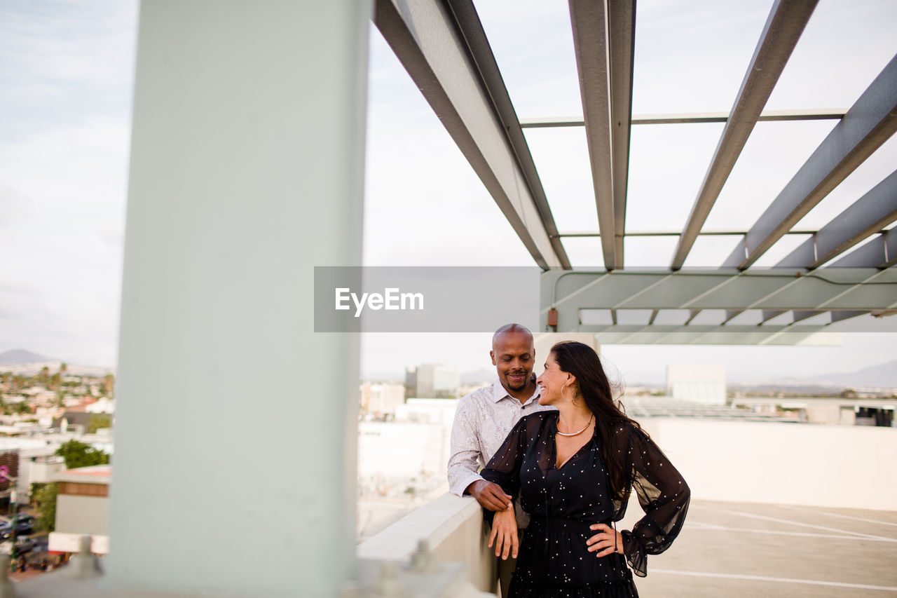 Multiracial late forties couple embracing at sunset in san diego