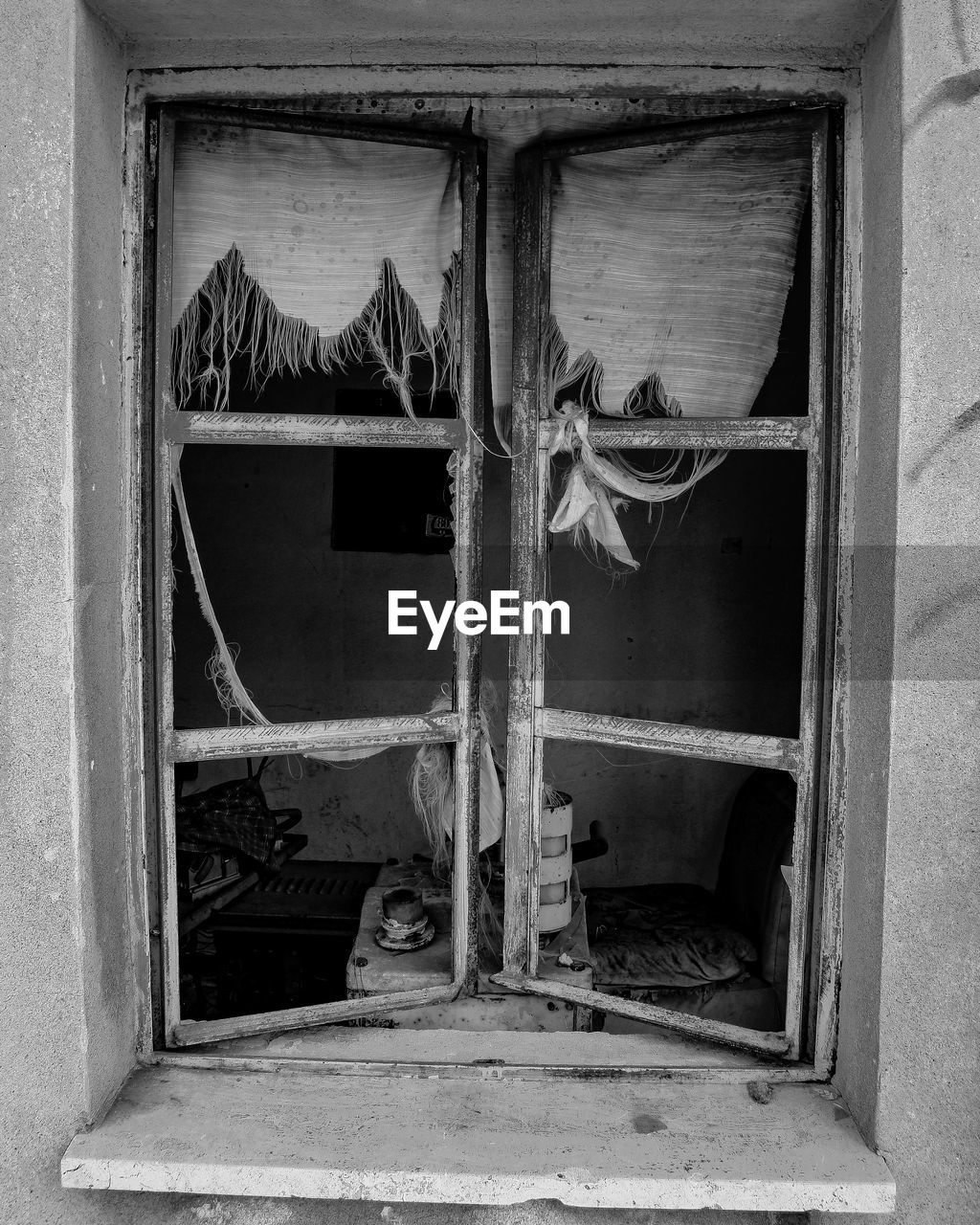 CLOSE-UP OF BROKEN WINDOW ON OLD BUILDING