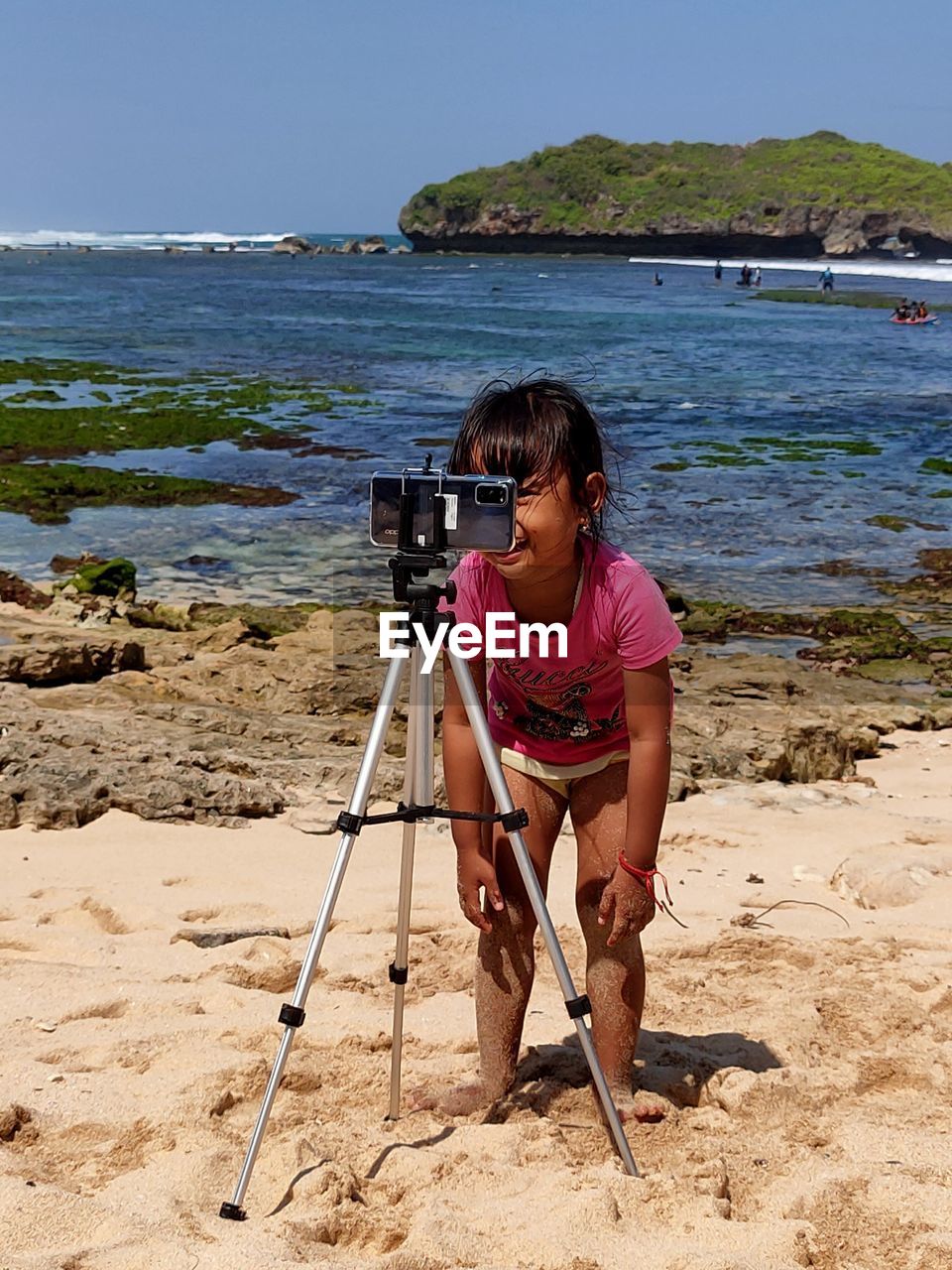 Full length of woman photographing on beach