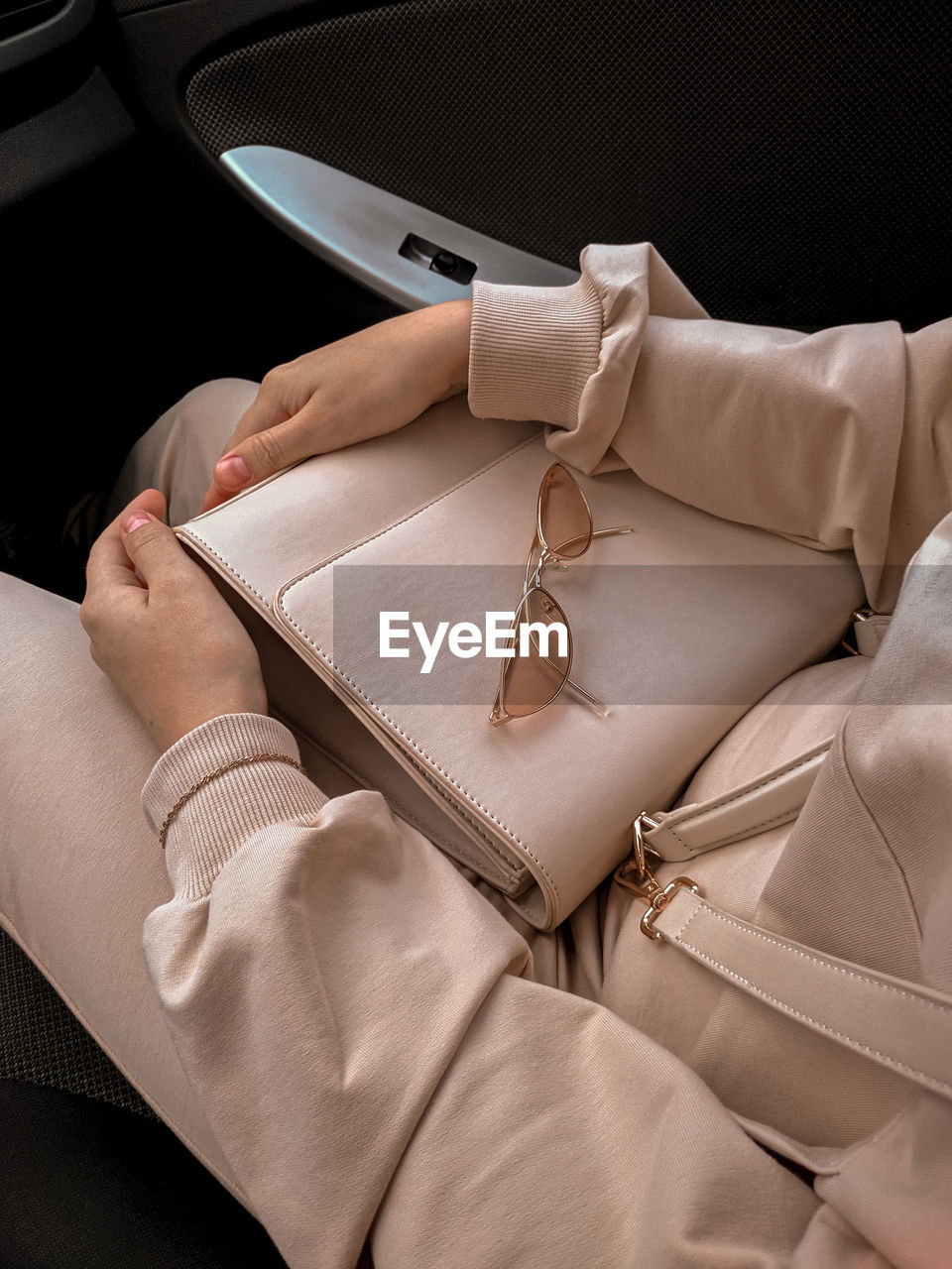 High angle view of woman with purse and sunglasses sitting in car