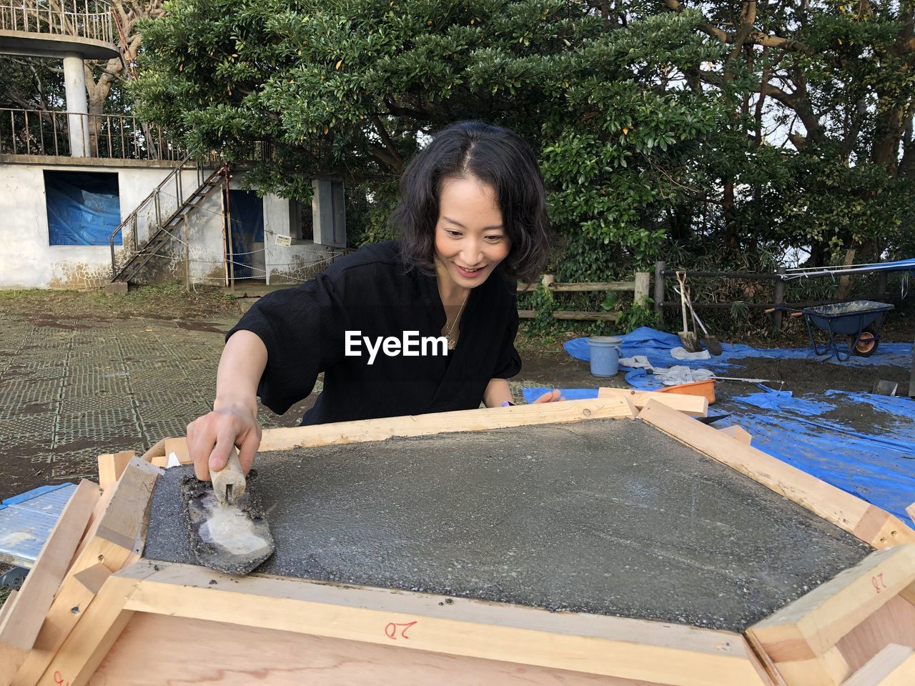 Woman plastering concrete outdoors