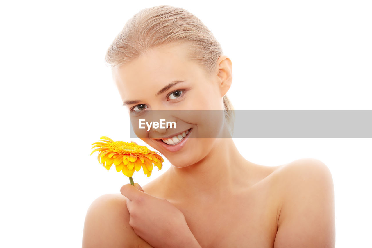 Portrait of woman with flower against white background