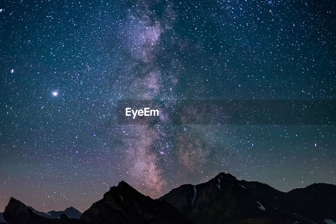 SCENIC VIEW OF MOUNTAIN AGAINST STAR FIELD