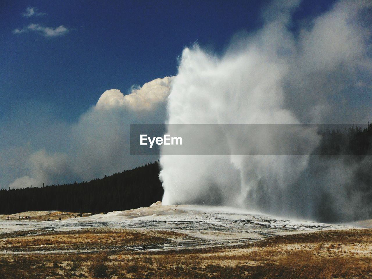 Scenic view of water spraying from geyser against sky