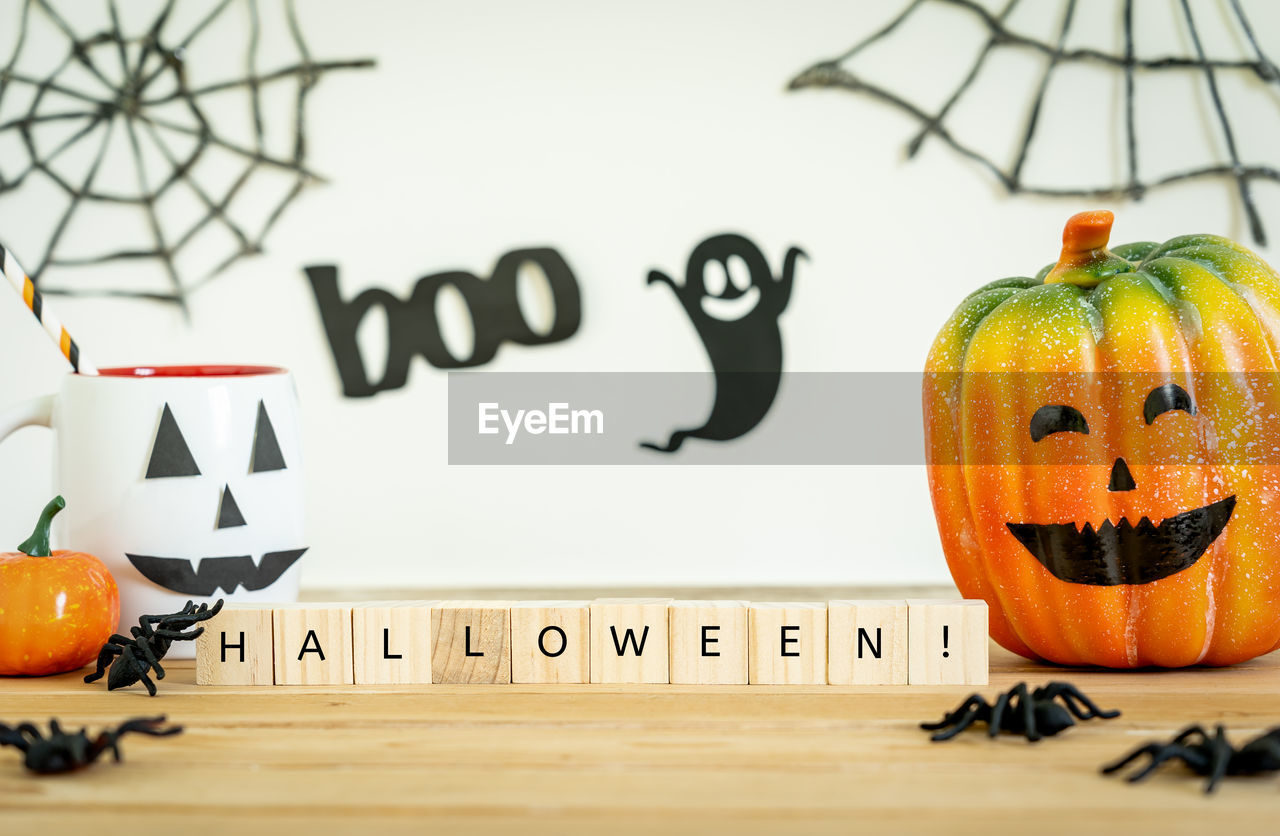 CLOSE-UP OF PUMPKIN ON TABLE AGAINST ORANGE WALL