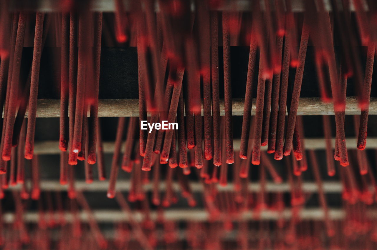 Full frame shot of red incense sticks hanging