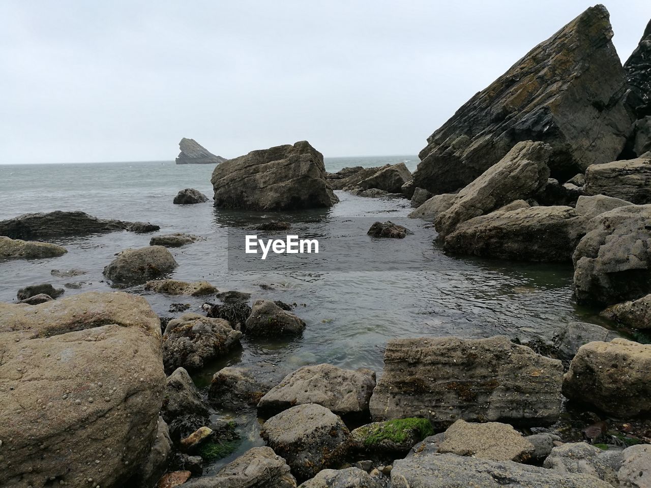 Rocks by sea against sky