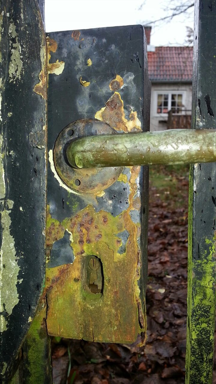 Close-up of rusty lock and handle on wooden door
