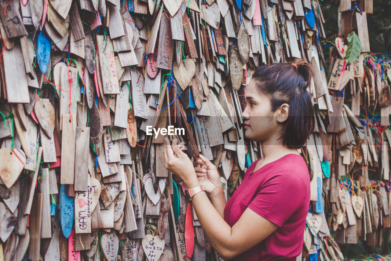 Woman looking at wooden prayer blocks in market