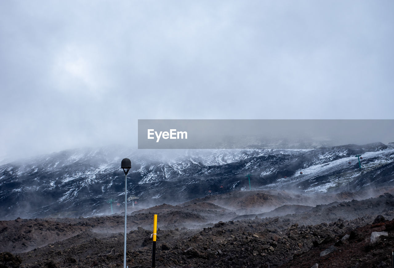 Scenic view of snow covered mount etna, sicily, against foggy sky