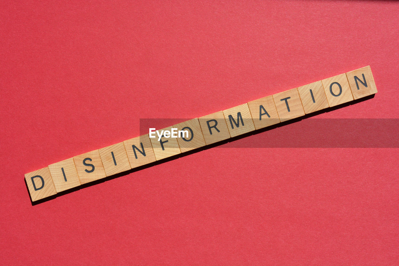 indoors, font, ruler, studio shot, text, red, no people, colored background, close-up, western script, communication, instrument of measurement, number, single object, pink, red background