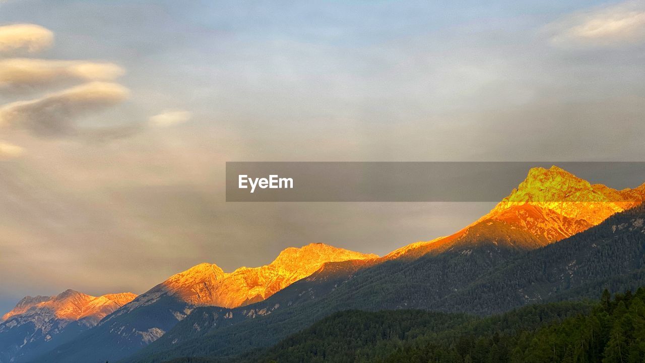 SCENIC VIEW OF MOUNTAINS AGAINST SKY DURING SUNRISE