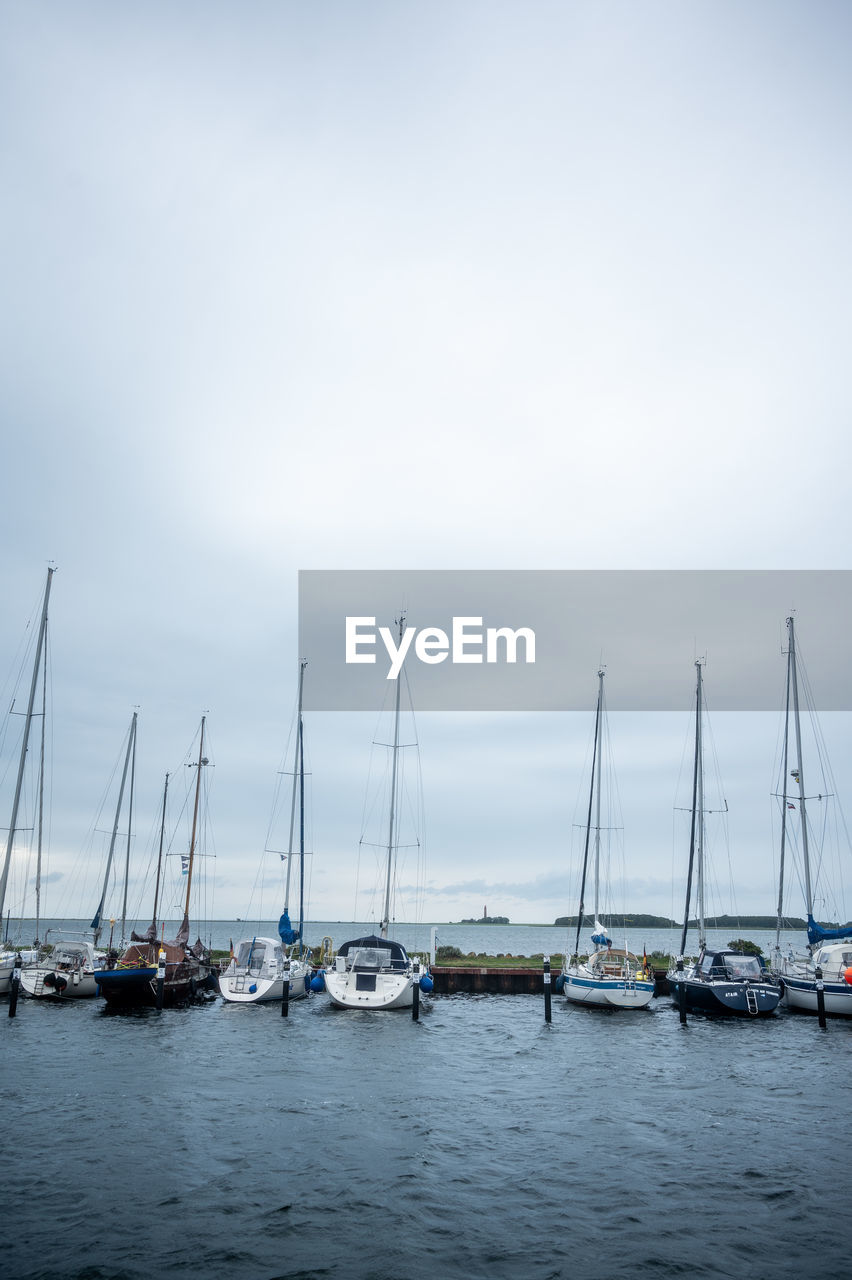 nautical vessel, water, transportation, sailboat, mode of transportation, sea, sky, pole, mast, harbor, marina, nature, boat, sailing, cloud, ship, no people, moored, vehicle, travel, beauty in nature, dock, tranquility, sailing ship, holiday, day, copy space, bay, tranquil scene, yacht, idyllic, outdoors, vacation, travel destinations, watercraft, trip, scenics - nature, blue, environment