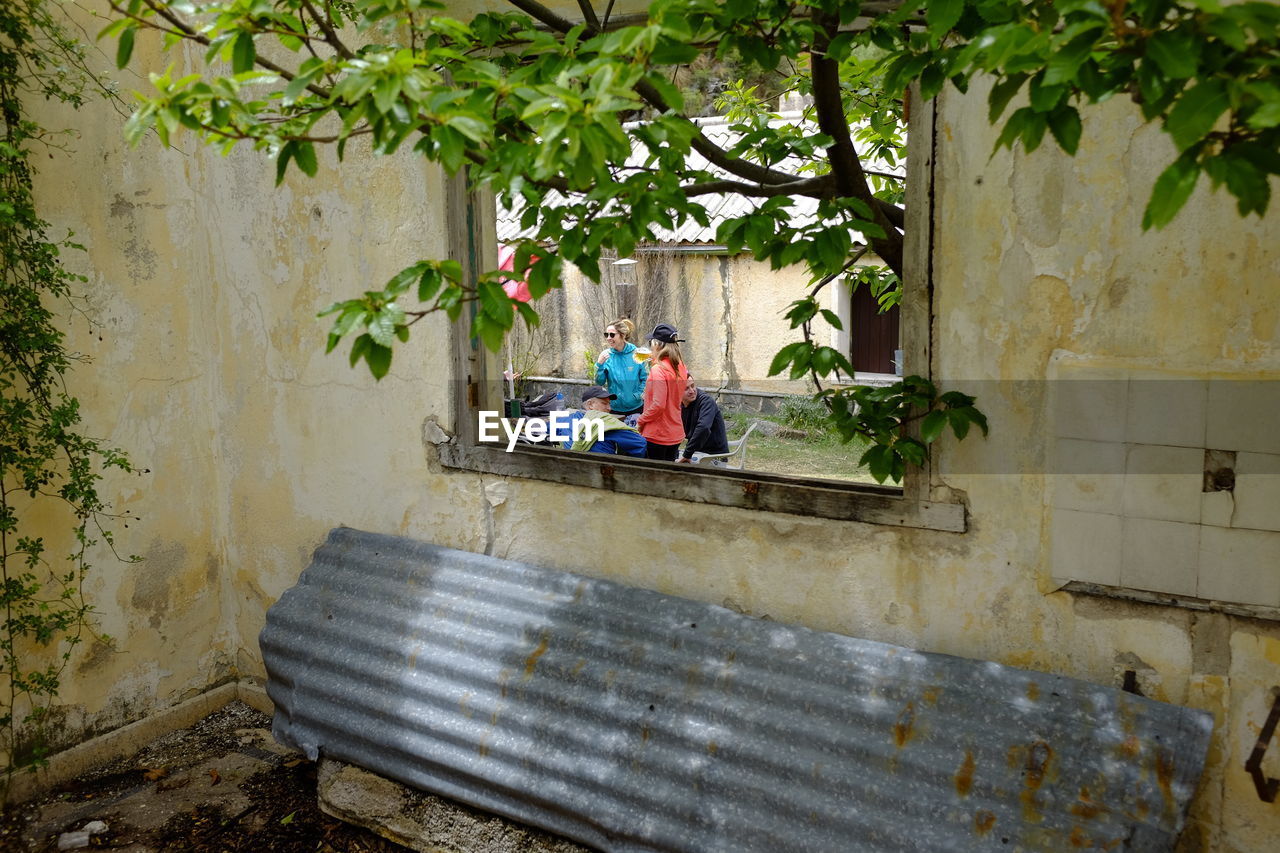 People on land seen through window