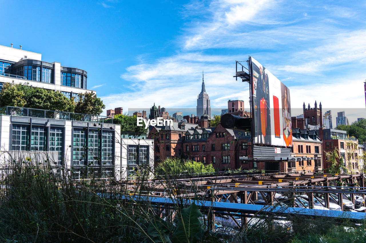 Buildings by river against sky in city