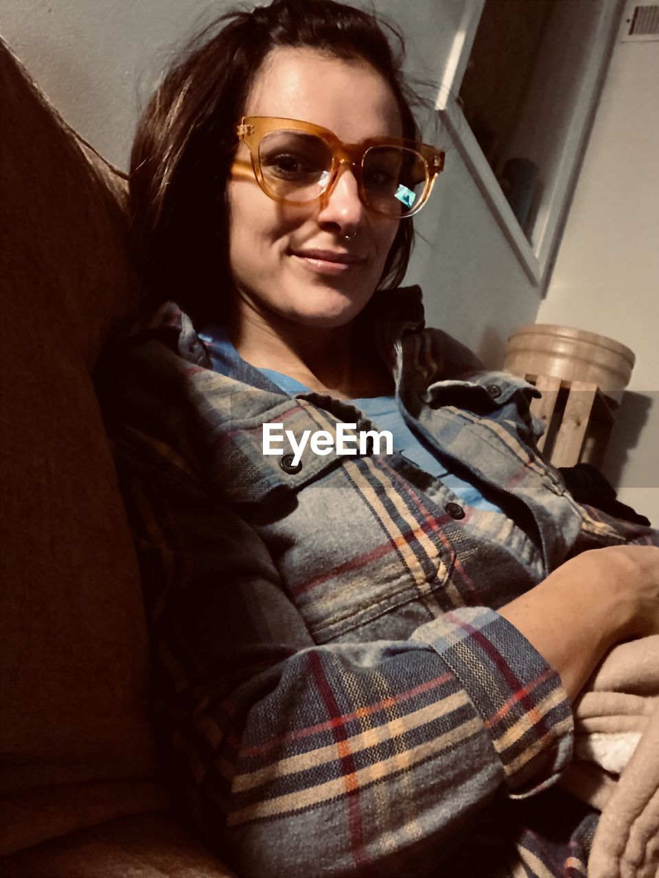 PORTRAIT OF WOMAN WEARING SUNGLASSES AT HOME