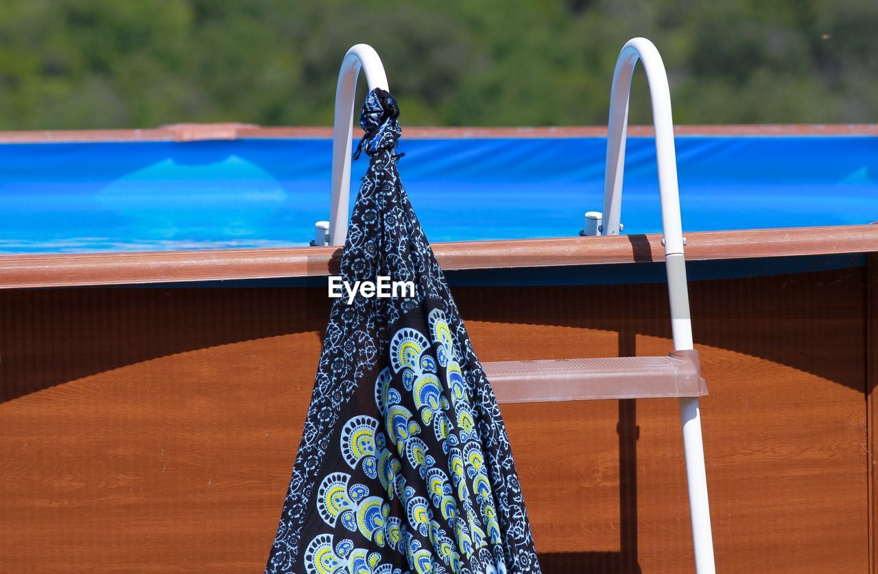 Pool ladder with hanging colored sarongs.