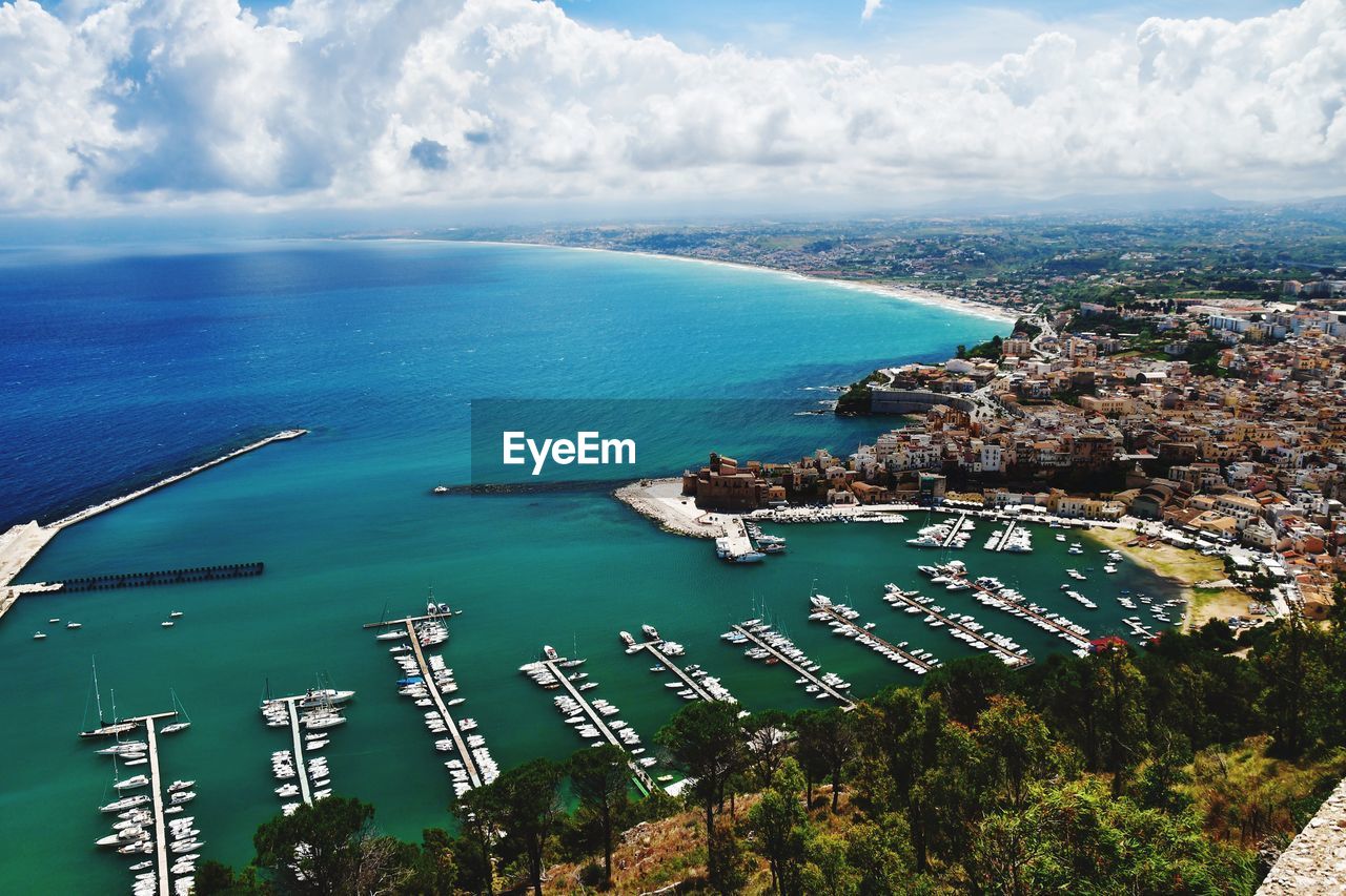 High angle view of sea and cityscape against sky