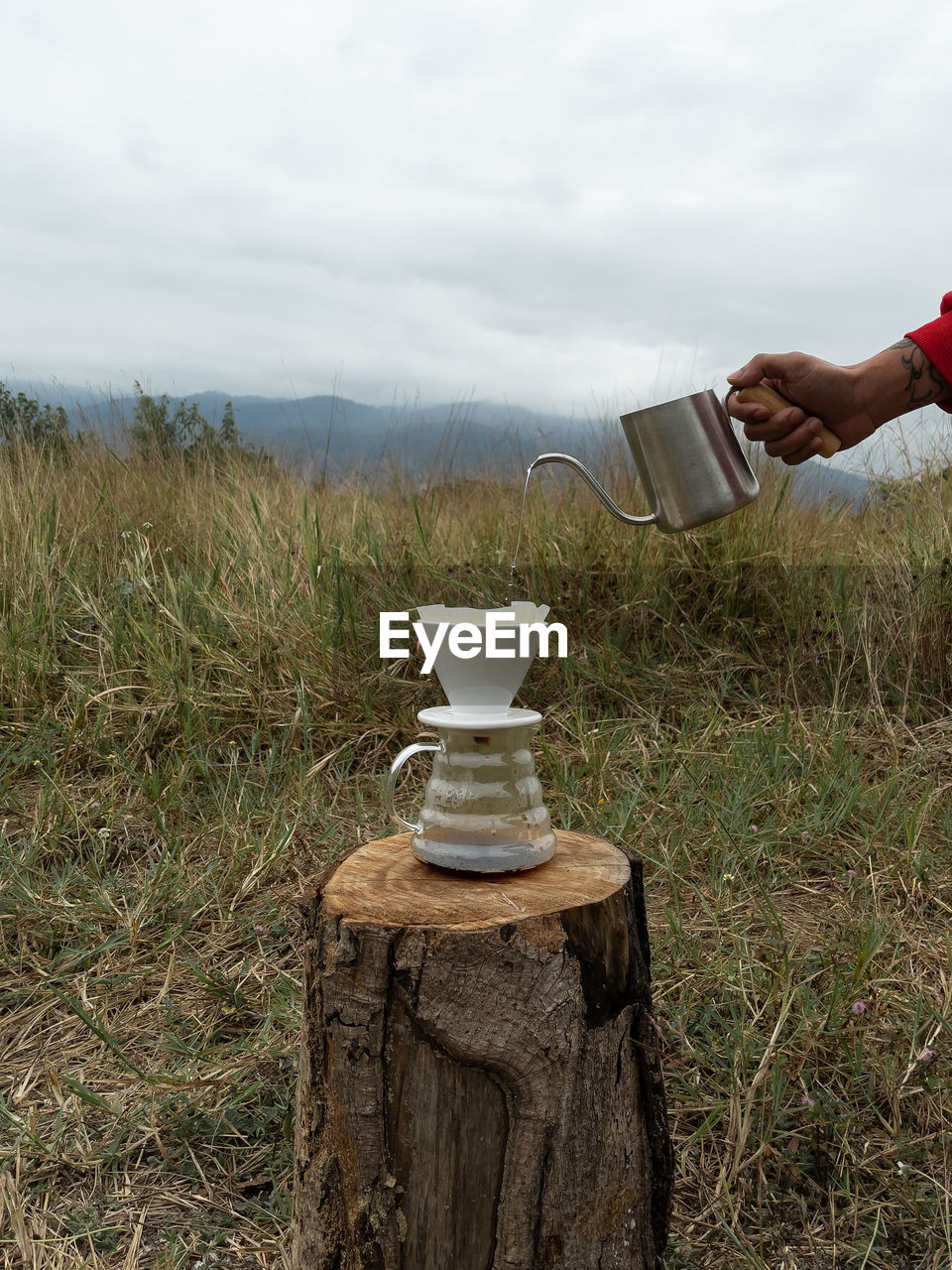 HAND HOLDING GLASS OF FIELD