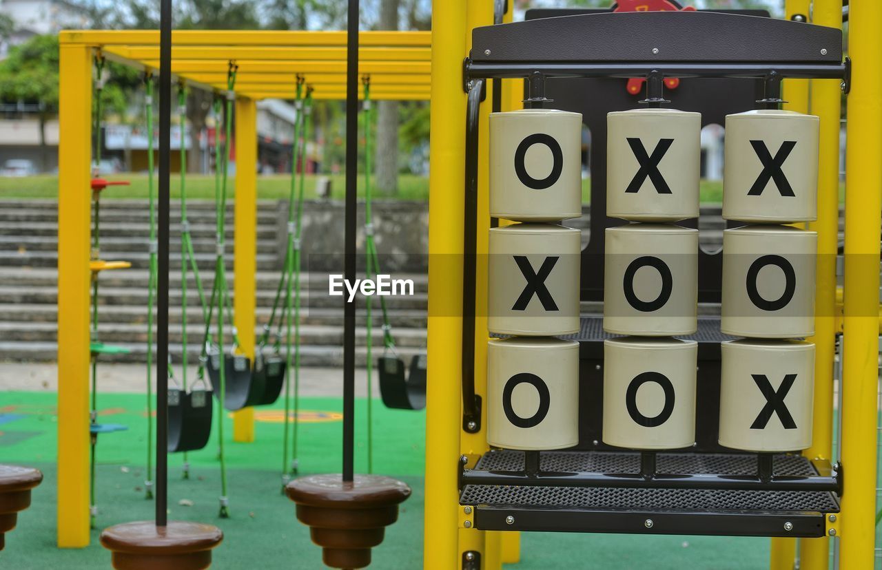 yellow, no people, day, communication, outdoor play equipment, city, sign, playground, outdoors, nature, text, number, metal, focus on foreground