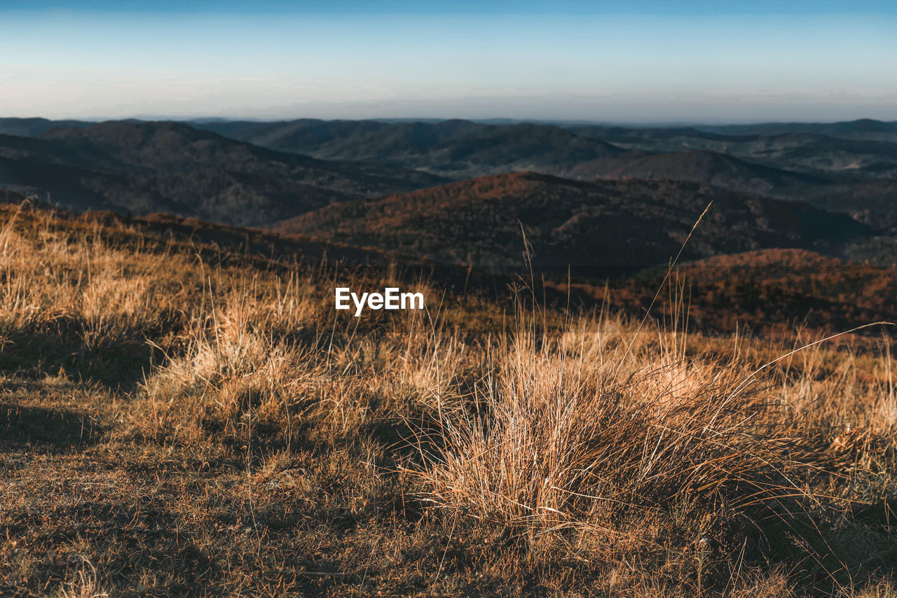 Scenic view of land and mountains against sky