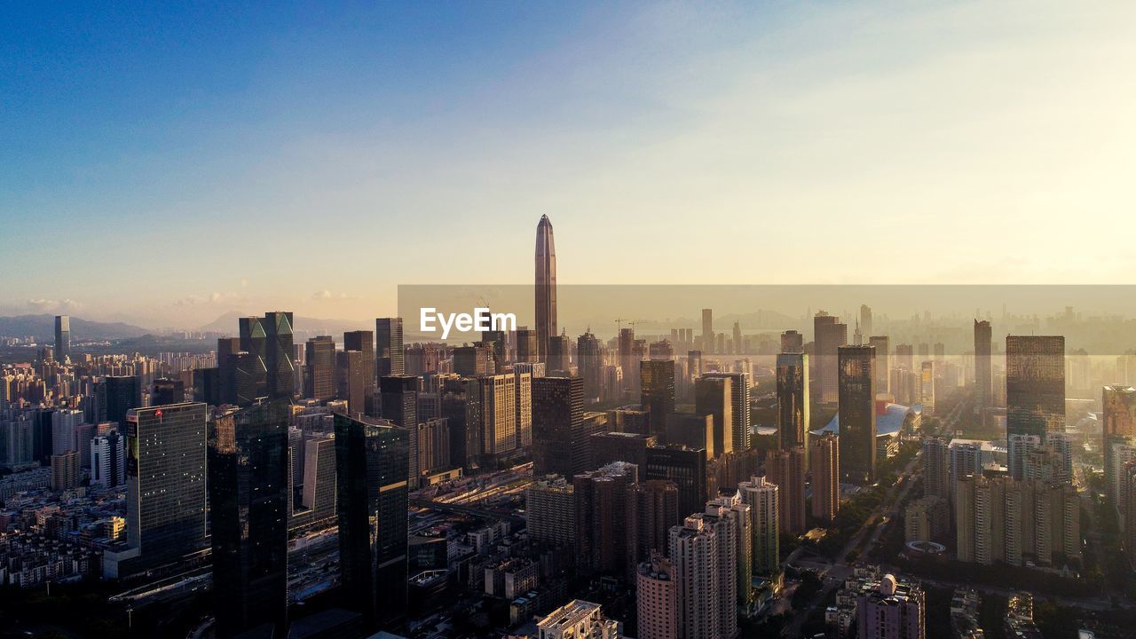 High angle view of city lit up at sunset