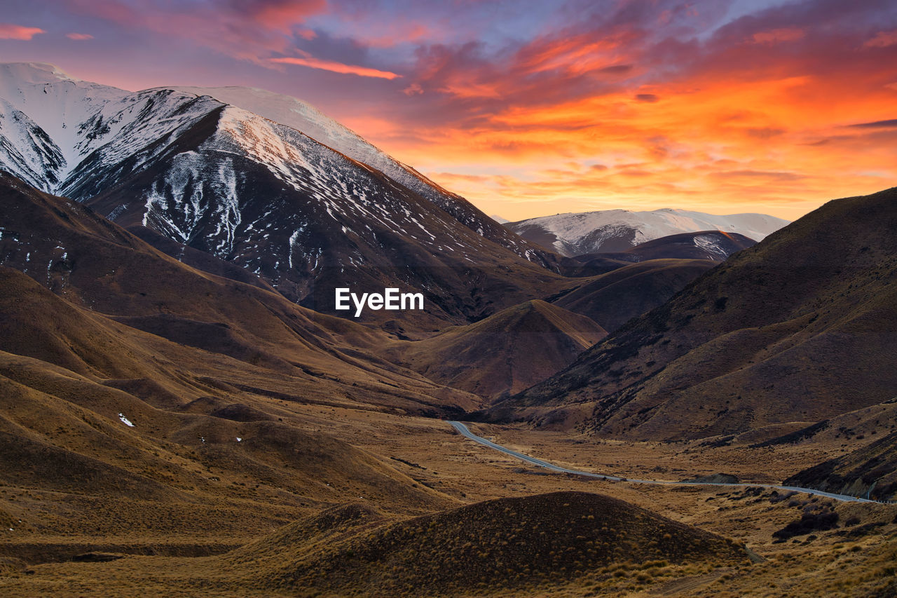SCENIC VIEW OF SNOWCAPPED MOUNTAINS DURING SUNSET