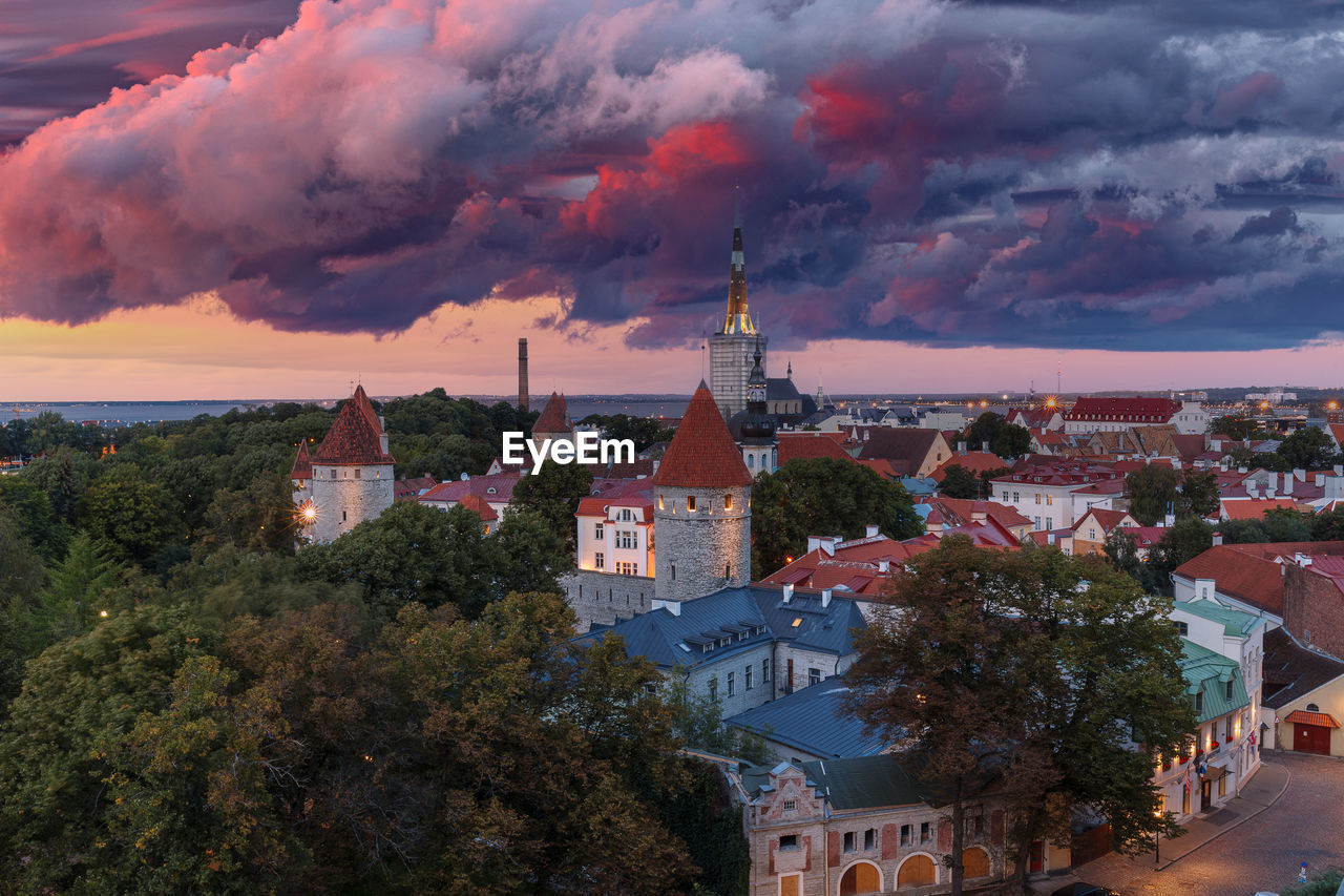 HIGH ANGLE VIEW OF TOWNSCAPE BY TREES AND BUILDINGS AGAINST SKY