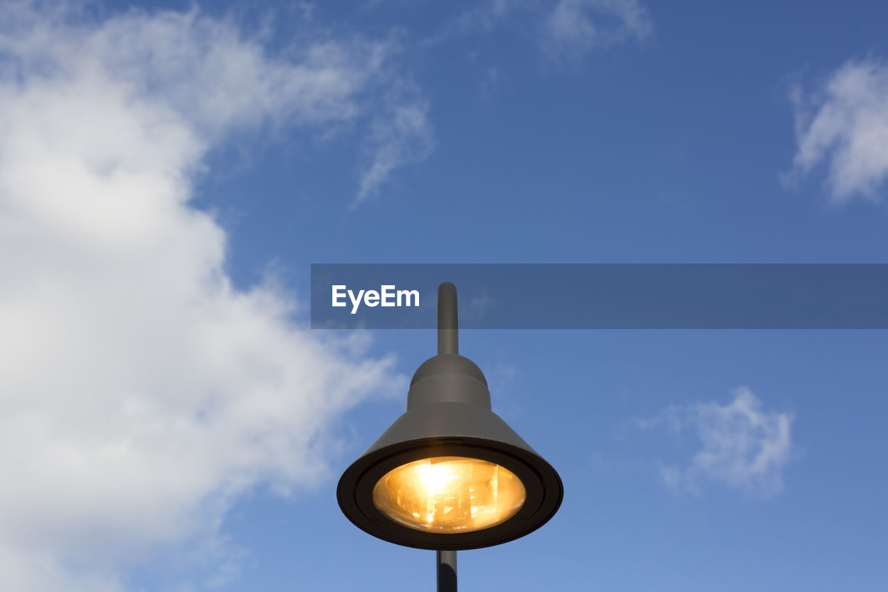 Low angle view of illuminated street light against blue sky