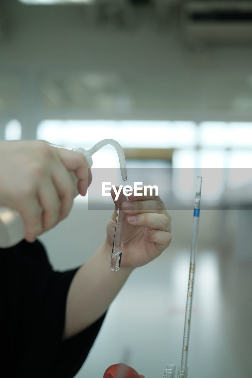 Cropped hands of scientist doing experiment in laboratory